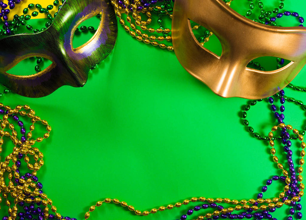 Mardi Gras mask with beads on a green background - Photo, Image