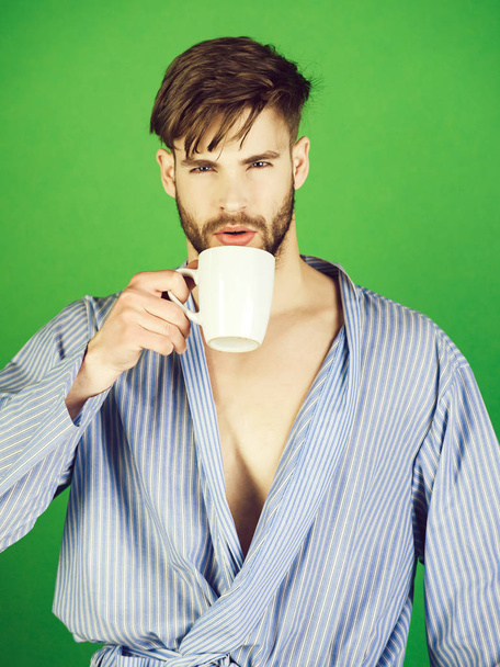 Bearded man drinking cup of tea or coffee in robe - Fotoğraf, Görsel