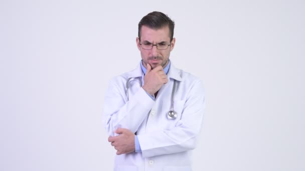 Young serious Hispanic man doctor thinking - Πλάνα, βίντεο