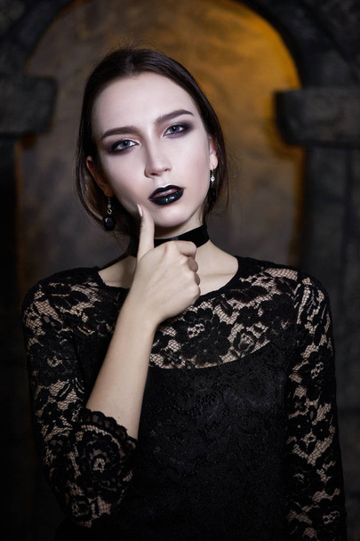 High Fashion Model Girl Portrait with Trendy gothic Black Make up, dark portrait. Halloween Vampire Woman with black matte lips over deep blue background. model girl face with black lipstick makeup. - Photo, image
