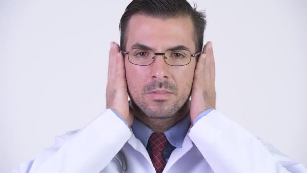 Young Hispanic man doctor covering ears as three wise monkeys concept - Filmagem, Vídeo
