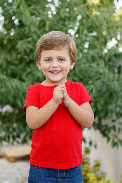 Happy child with red t-shirt playing in the garden  - Φωτογραφία, εικόνα