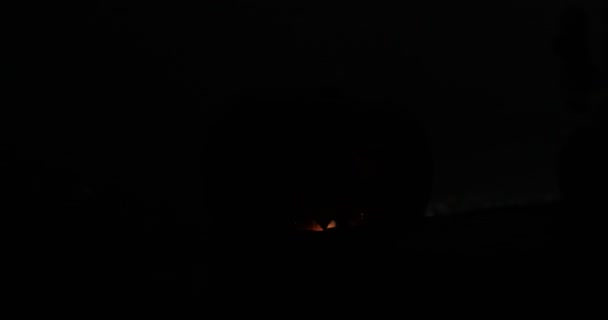 ホラーハロウィンのコンセプト。暗い背景で輝く恐ろしい死んだハロウィーンのカボチャの眺めを閉じます。10個のカボチャの頭。選択的焦点 - 映像、動画