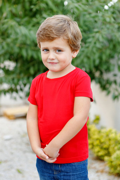 Happy child with red t-shirt playing in the garden  - Foto, immagini