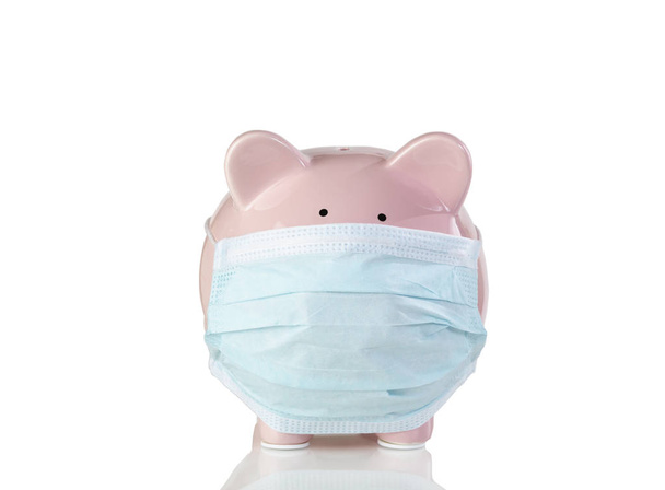 Piggy bank with surgical mask isolated on white background with reflection  - Foto, immagini