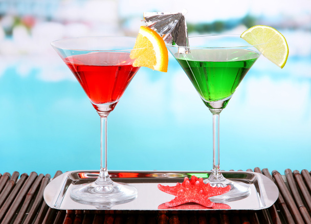 Bicchieri di cocktail sul tavolo vicino alla piscina
 - Foto, immagini