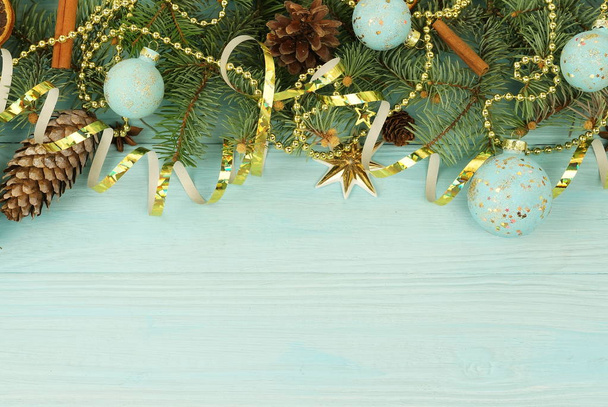 Weihnachtskomposition Hintergrund aus Tannenzweigen und goldblauen Dekorationen auf blauem Holzhintergrund. Weihnachten des kreativen Winterurlaubskonzeptes. Ansicht von oben. Kopierraum - Foto, Bild