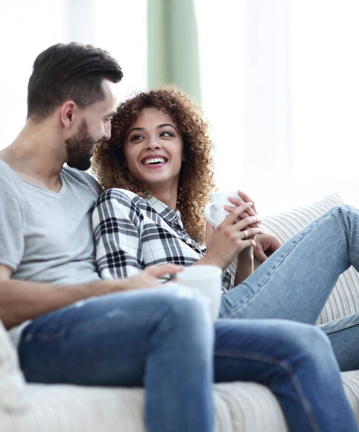 loving couple sitting on a sofa in the living room - Photo, image