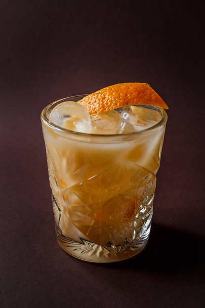 Copo de coquetel de álcool laranja com gelo e fatia de laranja no elegante fundo marrom escuro
. - Foto, Imagem