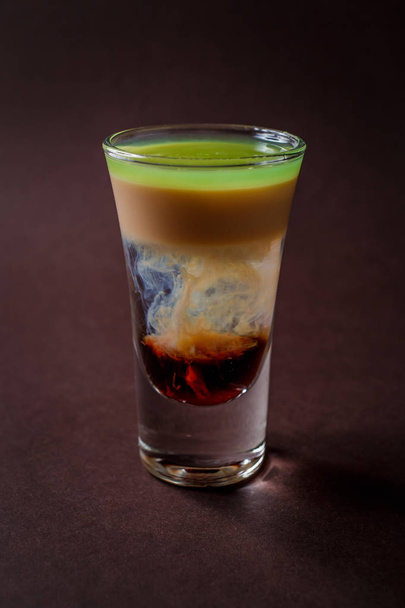 Hiroshima alcoholic shot glass with absent, sambuca, irish cream on elegant dark brown background. - Photo, Image