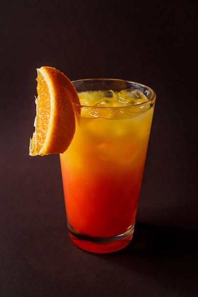 Jég és elegáns sötét barna alapon narancs szelet narancs koktél pohár. - Fotó, kép
