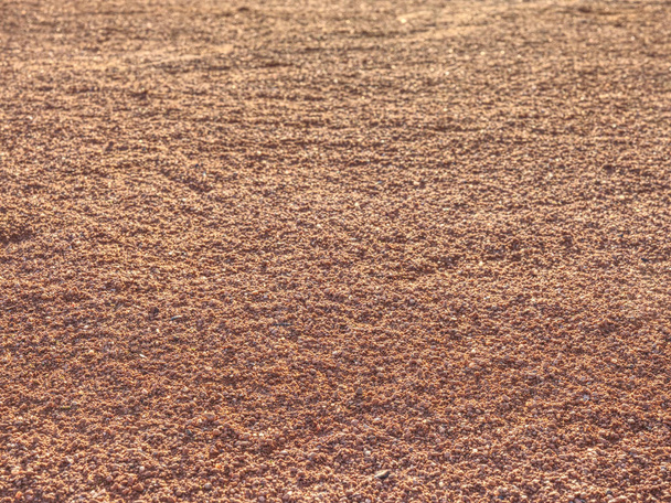 roter Sandplatz, der von Fußspuren von Tennisspielern und Soldaten zertrampelt wurde. Markierungen auf einem Tennisplatz im Detail - Foto, Bild