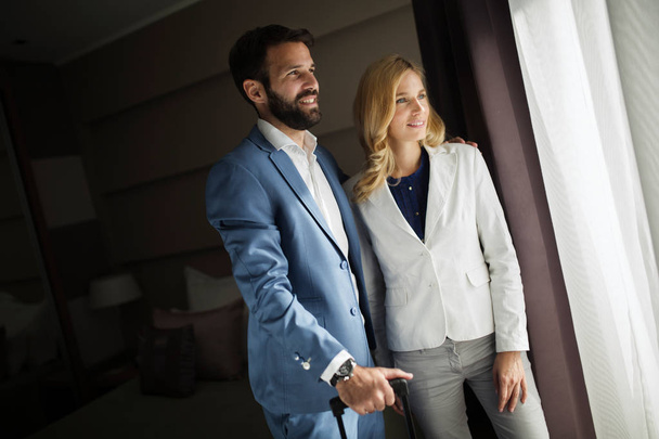 Picture of successful businessman and businesswoman in hotel room - Fotó, kép