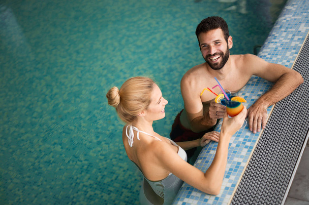 Joyeux couple heureux profitant ensemble dans la piscine au centre de spa
 - Photo, image