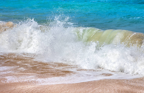 Blu acqua pesante dell'oceano spruzza sulla spiaggia sabbiosa
 - Foto, immagini