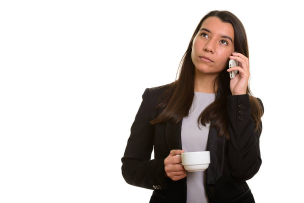 Thoughful young Caucasian businesswoman talking on mobile phone  - Photo, Image