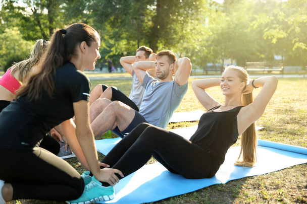 Group of sporty people training in park - Фото, изображение