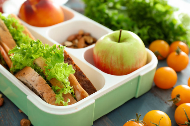 Lunch box with appetizing food on wooden table - Photo, Image