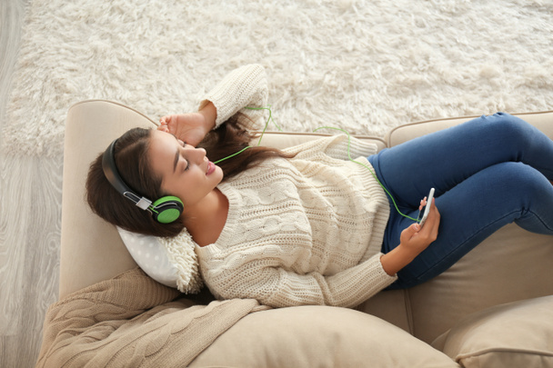 Gyönyörű fiatal nő zenét hallgat otthon. - Fotó, kép