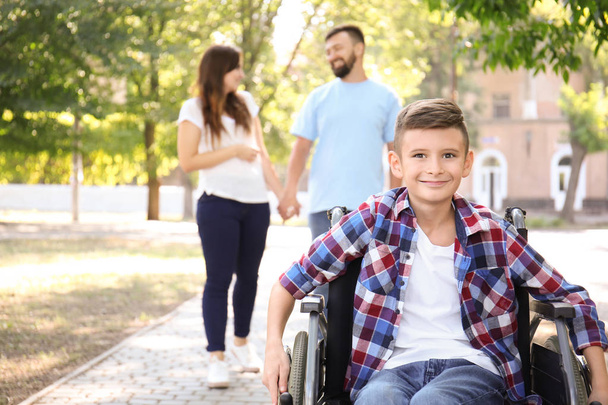 Nastoletni chłopak na wózku inwalidzkim wraz z rodziną, chodzenie na zewnątrz - Zdjęcie, obraz