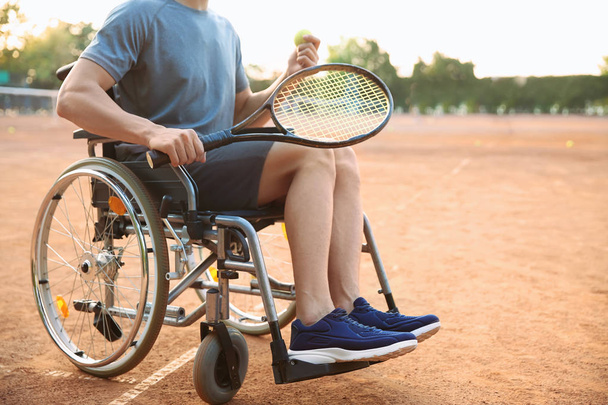 Junger Mann im Rollstuhl spielt Tennis auf Platz - Foto, Bild