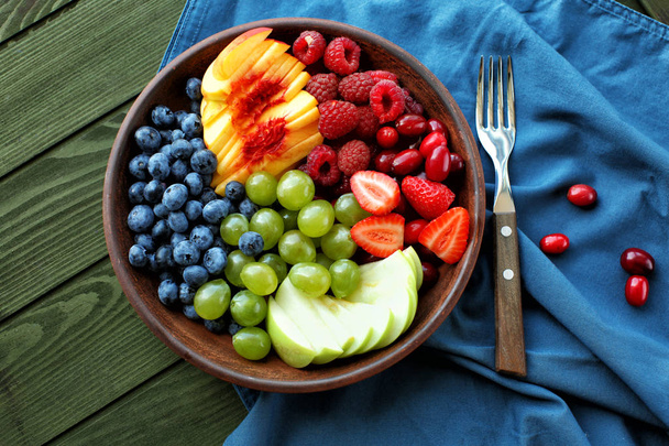 Assiette avec délicieuse salade de fruits sur table en bois
 - Photo, image