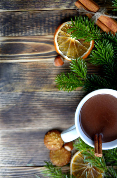 Hot chocolate or cocoa with cinnamon stick in a cup and fir branches. Winter hot drink for cold weather. New year and Christmas concept Top view - Photo, Image