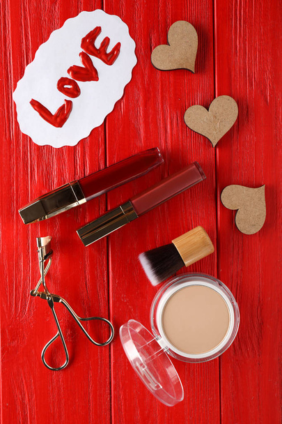 Set of cosmetics with word LOVE on color wooden background - Foto, Imagen
