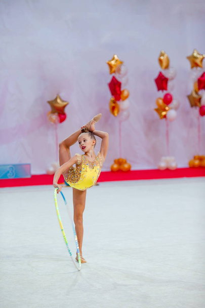 Beautiful little active gymnast girl with her performance on the carpet - Photo, Image