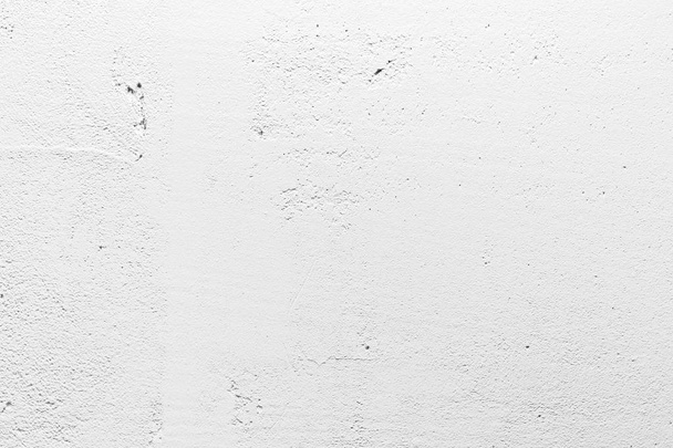 Witte muur van poreus materiaal. Lichte oneffen oppervlak met kleine gaatjes en scheuren. Textuur van oude witte betonnen wand voor achtergrond. - Foto, afbeelding