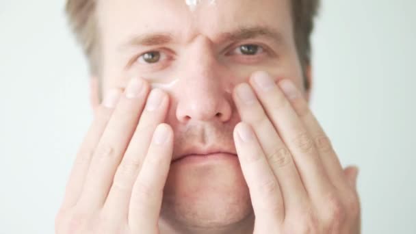 Mann schmiert Feuchtigkeitscreme ins Gesicht. - Filmmaterial, Video