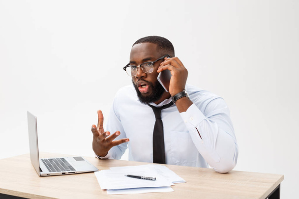 Empresario africano decepcionado es aturdido y confundido hablando por teléfono. Siente un total desacuerdo sobre el trato.
. - Foto, imagen