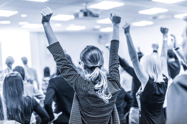 Participants of interactive motivational speech feeling empowered and motivated, hands raised high in the air. - Valokuva, kuva