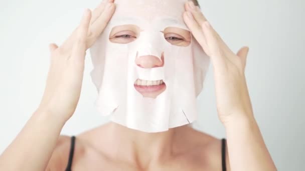 The girl puts a mask on her face. Facial skin care - Felvétel, videó