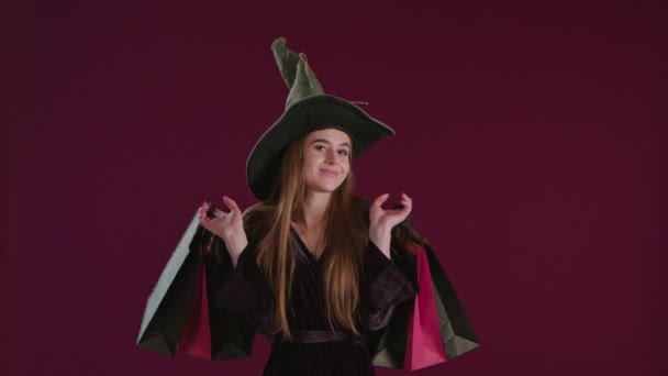 Lány a Halloween boszorkány jelmez a bevásárló szatyrok. - Felvétel, videó
