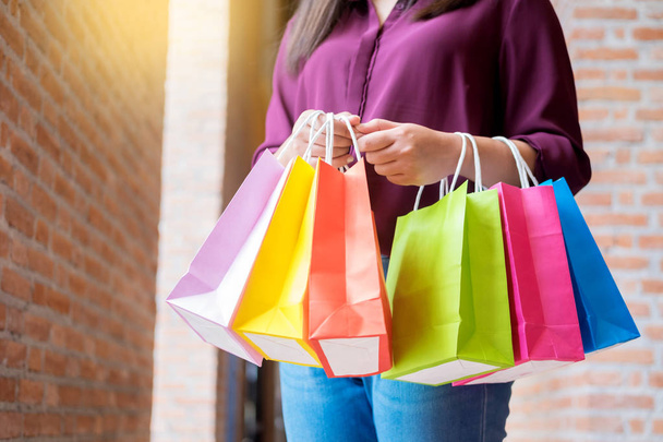 consumentisme vrouw houden veel shopping tassen in mode boutiqueafter het kopen van geschenken, genieten van verkoop en mensen concept - Foto, afbeelding