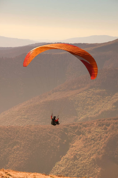 Paragliding in the Ukrainian Carpathians. People in parachute mountains. Autumn landscapes on a sunny day. Equipping for paragliding.Sportsmen.Sunsut and sunrise. - Photo, Image