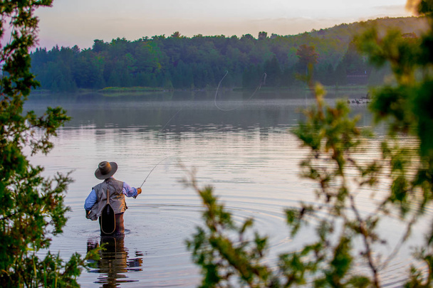 Молодой человек рыбачит на рассвете
 - Фото, изображение