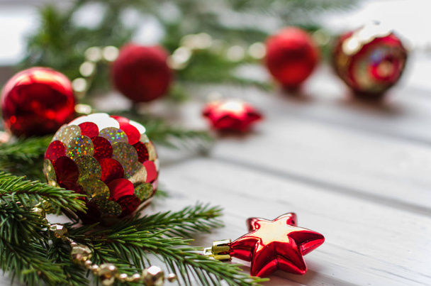 Рождественский фон с декором и веткой елки, покрытой снегом над деревянной текстурой. Красные шары и звезда
 - Фото, изображение