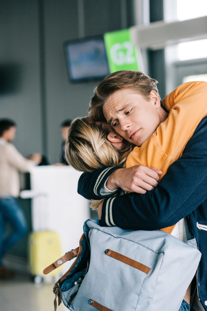 vista da vicino di emotivo giovane coppia abbracci in aeroporto terminale
 - Foto, immagini