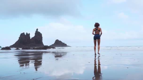 Aktív sportos nő szaladni ocean surf víz medence tartani fit és egészség. Naplemente fekete homokos strand háttér nap. Női fitness, jogging edzést és sport tevékenység a családi nyaralás. - Felvétel, videó