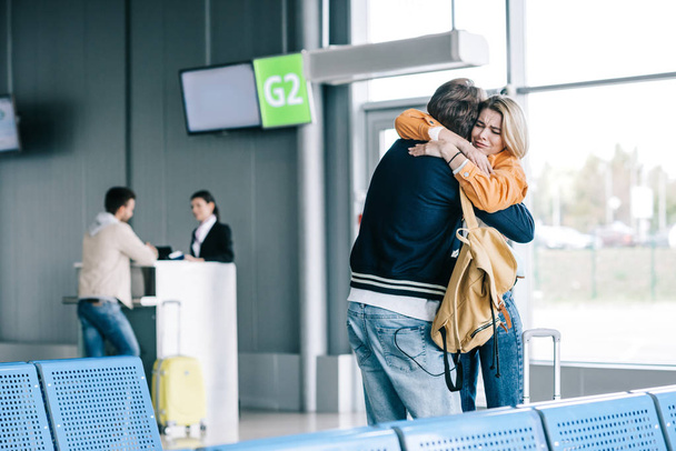 havaalanında sarılma duygusal genç çift  - Fotoğraf, Görsel