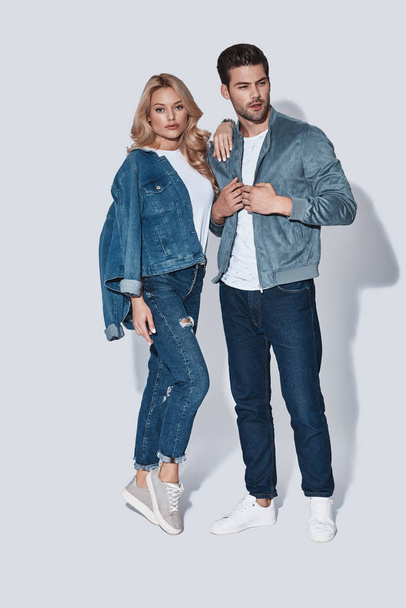 fashionable man and woman in denim wear standing in studio and posing  - 写真・画像