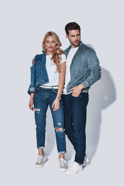 confident Full length of trendy fashionable man and woman in denim wear posing in studio  - Foto, afbeelding