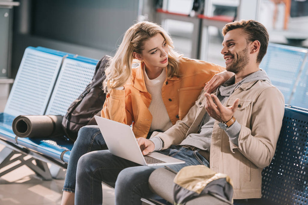 young couple using laptop while waiting in airport  - Foto, Bild