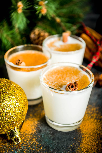 Boże Narodzenie eggnog nalewka napój lub cola de mono koktajl. tradycyjne zima koktajl w okularach krótki, z ozdoby xmas, ciemne tło - Zdjęcie, obraz
