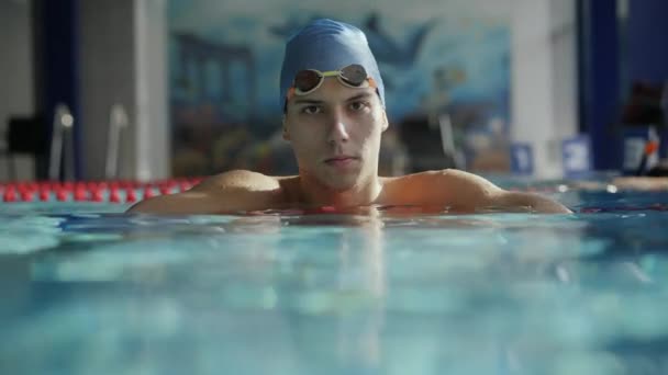 Nadador olhando para a câmera inclinada no caminho de divisão na piscina
 - Filmagem, Vídeo
