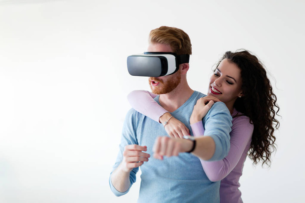 Attractive young couple trying virtual reality headset at home - Fotoğraf, Görsel