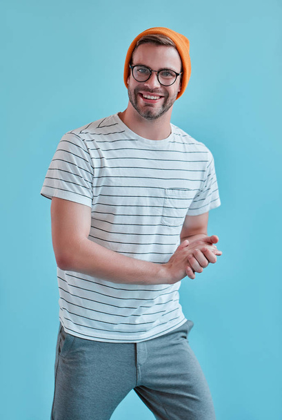 Handsome man isolated. Stylish young man in eyeglasses is  posing on blue background. - Φωτογραφία, εικόνα