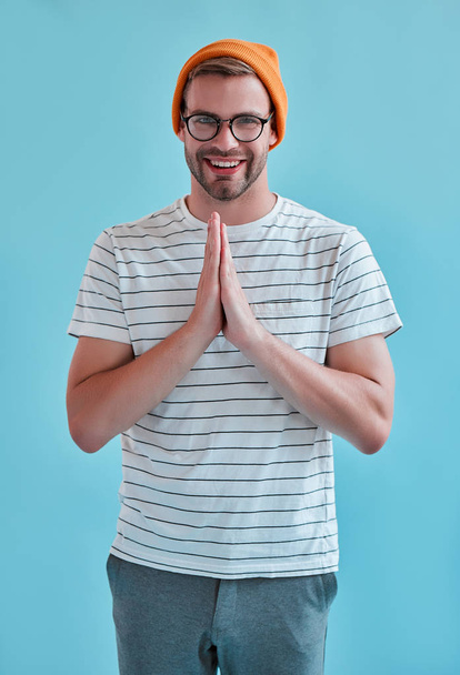 Handsome man isolated. Stylish young man in eyeglasses is  posing on blue background. - Фото, зображення